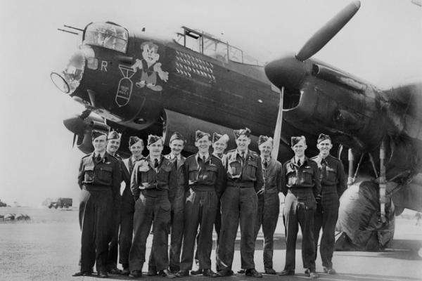 Pilots stand in front of a plane