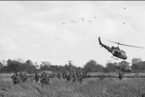 This photograph taken by Michael Coleridge in 1967, shows RAAF and American helicopters in the sky and swooping over a rice paddy in South Vietnam as they land troops of the 6th Battalion, The Royal Australian Regiment (6RAR), into a landing zone for a search and destroy operation south-east of the Task Force base at Nui Dat.  Taken during the first tour of 6RAR, the scene would have looked much the same to Mick two years later during Operation Mundingburra. Australian War Memorial, Photographs Collection 