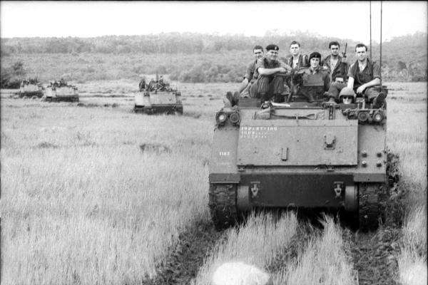 VIETNAM. 1966-08-19. TROOPS OF 6TH BATTALION, ROYAL AUSTRALIAN REGIMENT (6RAR) ON BOARD ARMOURED PERSONNEL CARRIERS (APC'S) OF NO 1 APC SQUADRON WAITING TO RETURN TO BASE AT NUI DAT AFTER THE LONG TAN BATTLE DURING OPERATION SMITHFIELD.