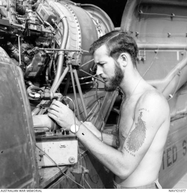 In South Vietnam, 1970, an unidentified member of the Royal Australian Navy performs maintenance work on a US helicopter. 