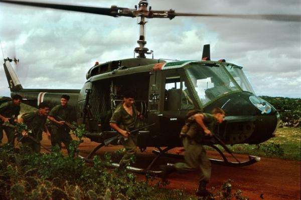 Soldiers stand by a helicopter in Vietnam