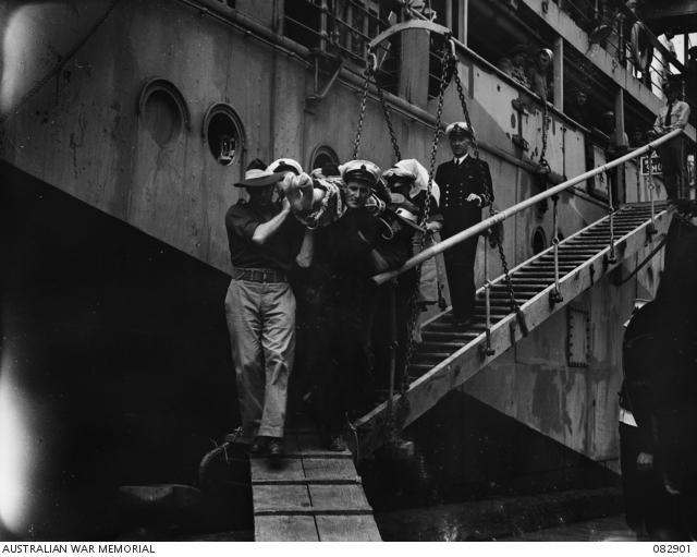 Commodore Collins, injured in the attack on HMAS Australia, is carried from an American merchant ship to a waiting ambulance.