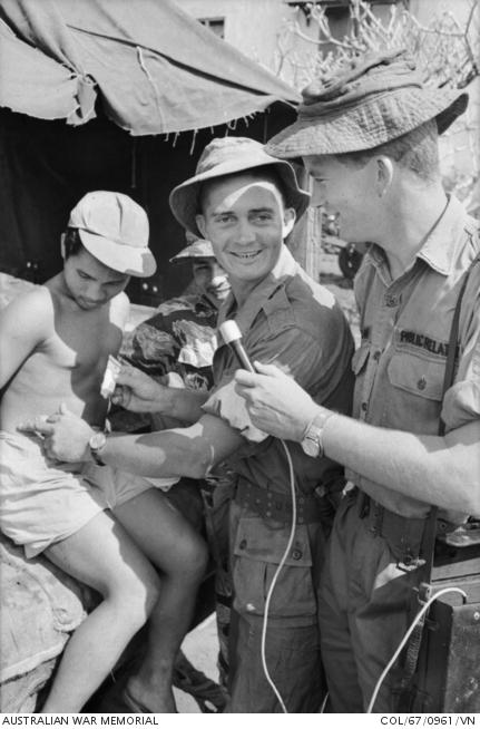 Vietnam. 1967-10. Sergeant Wayne Grant of Burnie, Tas, and Australian Army Public Relations Team interviews Warrant Officer (WO) Class 2 Ron Seiler of Wagga Wagga, NSW, and the Australian Army Training Team Vietnam (AATTV) at Binh Ba outpost, six miles north of Nui Dat. 