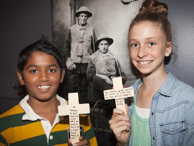 Commemorative Cross Project. School children from Hartwell Primary School visiting the Australian War Memorial write messages on crosses that will then be placed in cemeteries and on memorials of Australian servicemen and women worldwide. PAIU2013/021.11